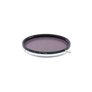 Nisi ND-Vario 82mm-1 Ympyränmuotoinen kameran linssisuodatin, jossa on musta ja hopeinen reunus, numeroitu 1-5 ja merkitty MAX. Suodattimen sivussa on pieni metallivipu, ja se on asetettu valkoista taustaa vasten.