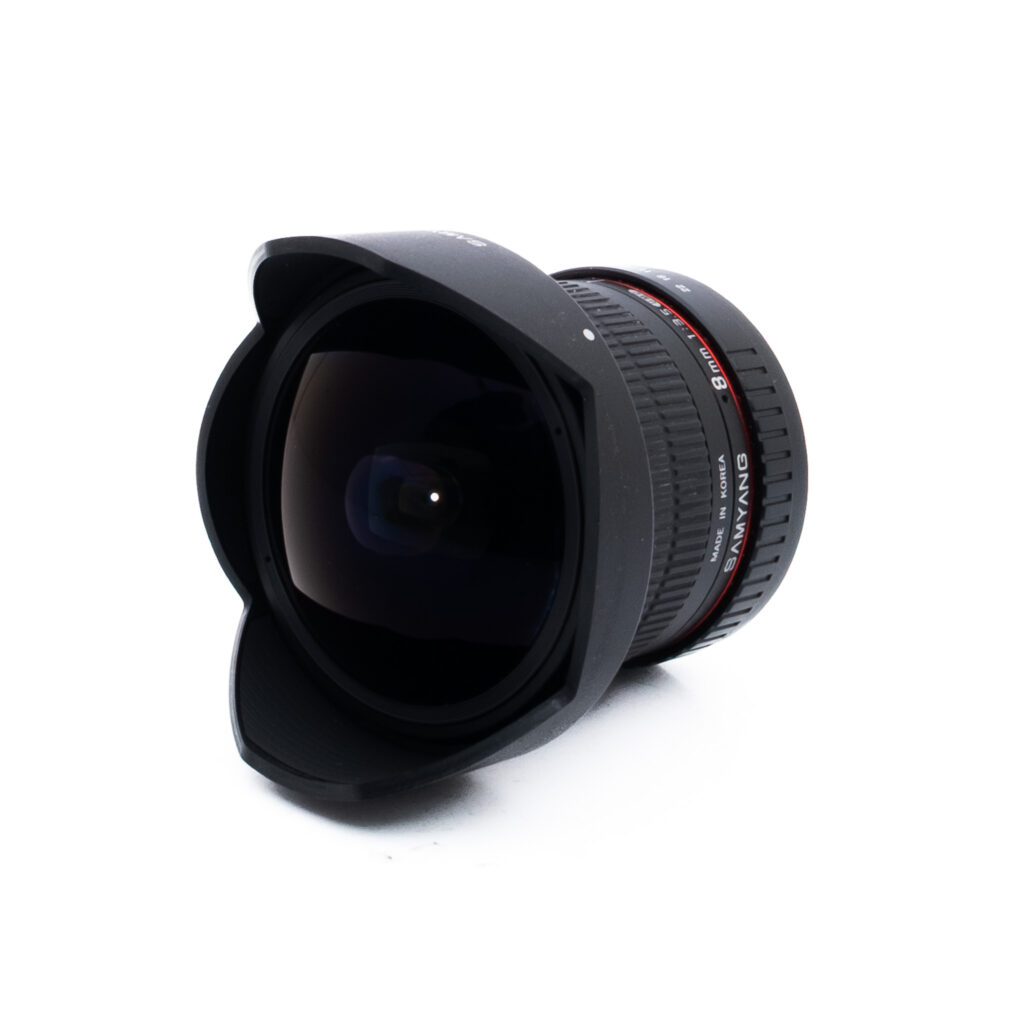 Samyang 8mm f35 UMC-2-2 Laajakulmakameran objektiivi, jossa on suuri, kaareva etuelementti ja terälehden muotoinen linssinsuojus, kuvattuna valkoisella taustalla.