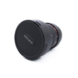 Samyang 8mm f35 UMC-3-2 Mustalla suojuksella varustettu kameran objektiivi, jossa on merkintä Samyang, on kuvattu kulmassa valkoisella taustalla. Objektiivissa on harjatut tarkennusrenkaat ja aukkorenkaat, joissa on punaiset ja valkoiset merkinnät.