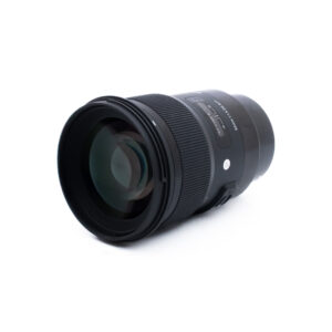 Sigma 50mm f14 DG Sony-2-2 Sigma 50mm f/1.4 Art DG Sony FE -objektiivi (sis. ALV 25,5%) - Käytetty, musta, jossa on suuri etuelementti, tarkennus- ja zoomausrenkaat sekä näkyvä tuotemerkki, sijaitsee vaakasuorassa valkoisella pohjalla.