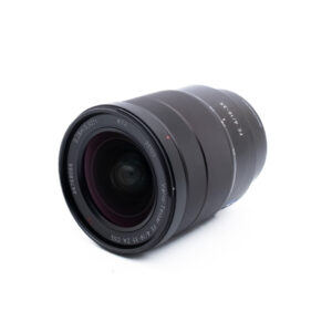 Sony 16-35mm f4 ZA OSS-2-3 Musta kameran linssi, jossa on näkyviä lasielementtejä ja merkintöjä ja joka lepää vinossa valkoisella pohjalla.