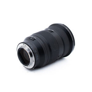 Sony 24-70mm f28 GM II-1 Musta kameran objektiivi, jossa on kuvioitu kahva, kuvattuna kulmasta valkoisella pohjalla, jossa näkyy objektiivin kiinnitys ja osa lasista.