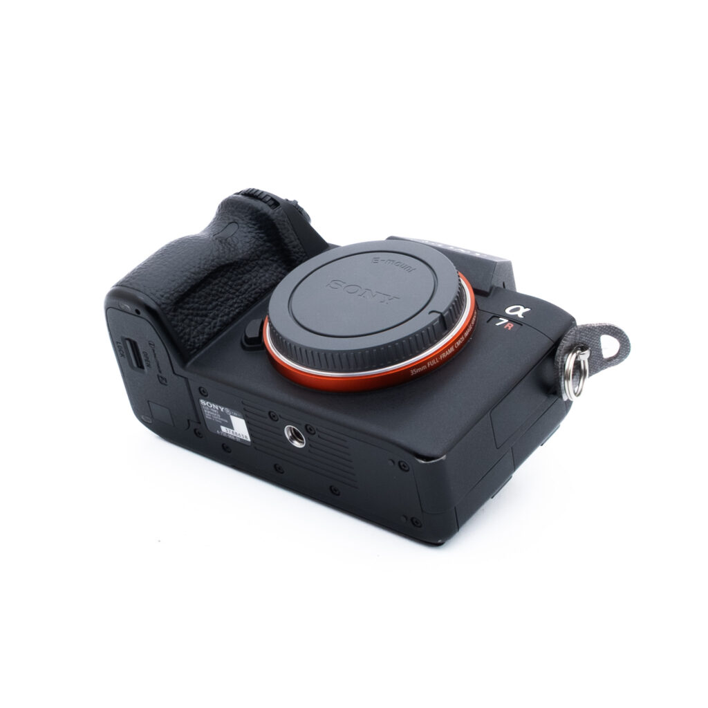 Sony A7R III 8638-1 Musta Sony Alpha -peilittömän digitaalikameran runko on kuvattu kulmassa valkoisella taustalla ilman objektiivia ja objektiivin kiinnityssuojus paikallaan.