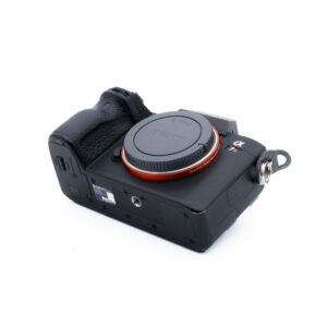 Sony A7R III 8638-1 Musta Sony Alpha -peilittömän digitaalikameran runko on kuvattu kulmassa valkoisella taustalla ilman objektiivia ja objektiivin kiinnityssuojus paikallaan.
