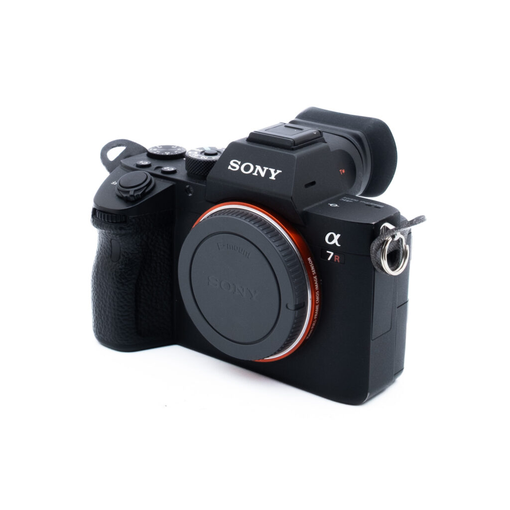 Sony A7R III 8638-5 Musta peilitön Sony Alpha 7R -digitaalikamera, jossa on objektiivin suojus ja joka on sijoitettu vinoon valkoiselle taustalle.