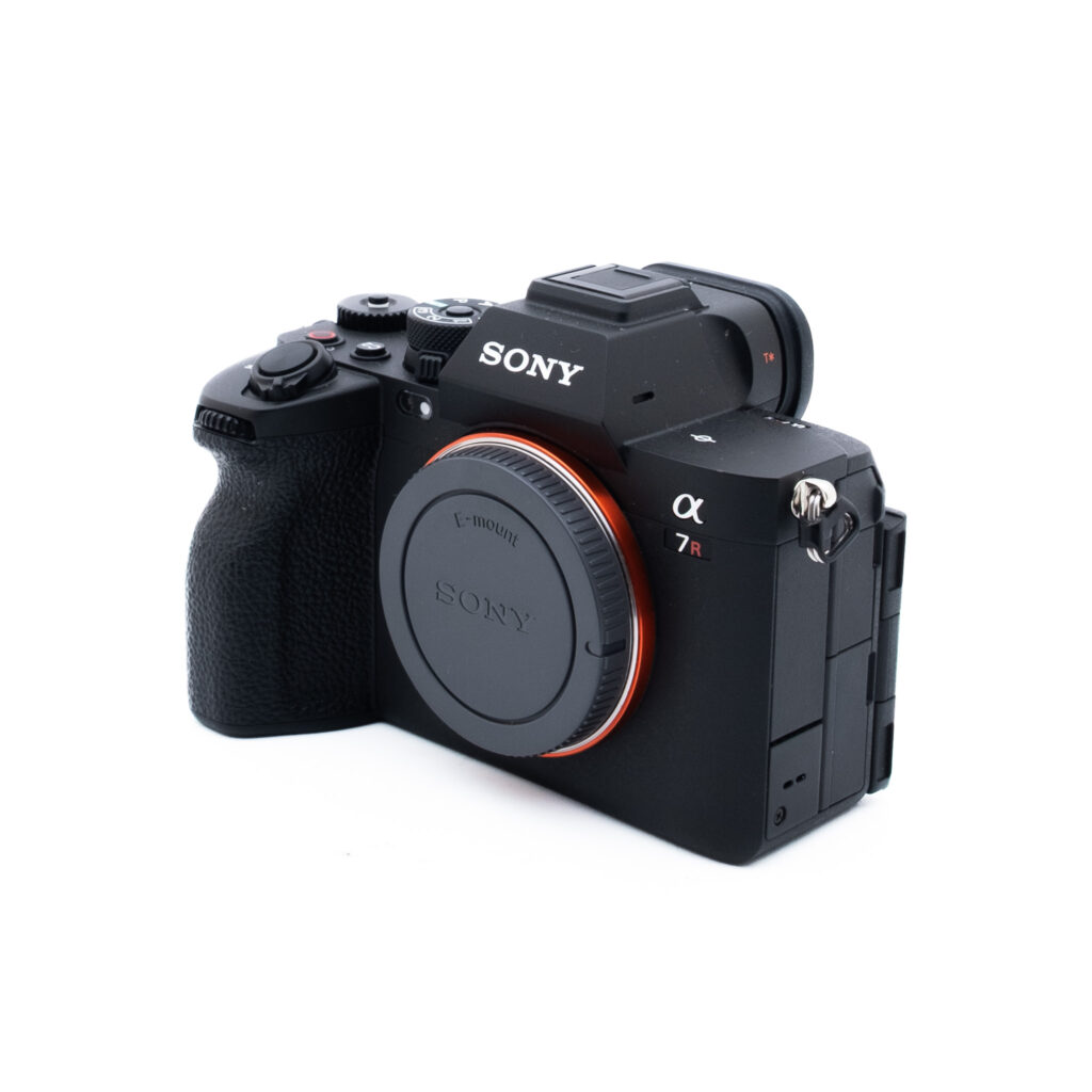 Sony A7R V 0622-5 Musta Sony Alpha 7R -peilitön digitaalikamera näkyy valkoisella taustalla hieman vasemmalle suunnattuna, ilman kiinnitettyä objektiivia ja objektiivin suojus paikallaan.