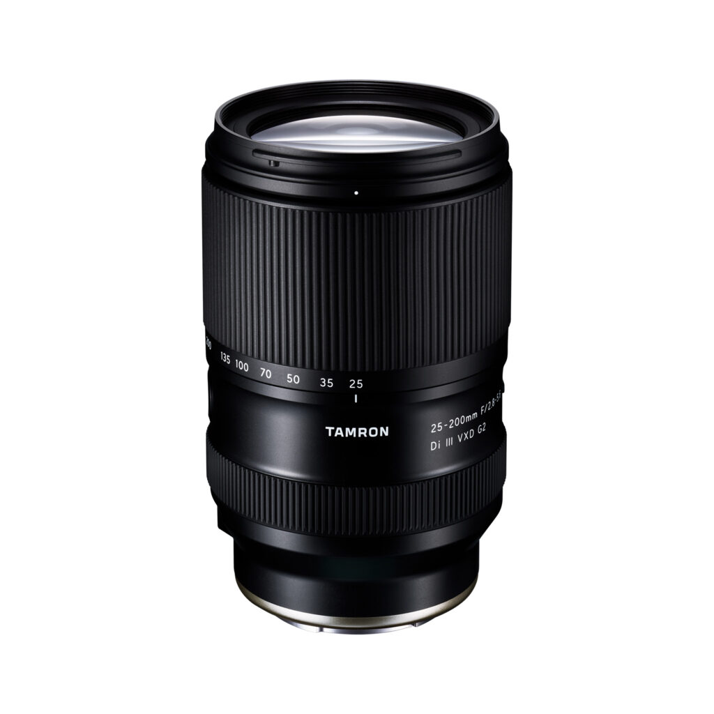 Tarmon25-200mm1 Tamron 25-200mm f/2.8-5.6 Di III VXD G2 Sony E -kameran musta objektiivi seisoo pystyssä valkoisella taustalla, ja sen zoomaus- ja tarkennusrenkaat sekä 25-200mm polttovälin merkinnät ovat näkyvissä.