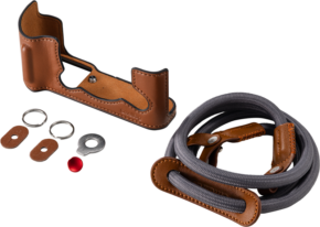 800q-01_135078 SmallRig 5670 Leather Half Case Kit for Fujifilm X-T30/II/III (brown) includes a brown leather half case, a compatible strap with leather trim, two metal rings, two leather ring covers, a metal washer and a small red button on a light-coloured background.