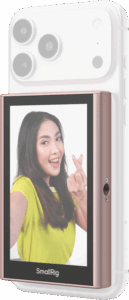 800q-01_135150 Keltaiseen paitaan pukeutunut nainen hymyilee ja tekee sormella sydäntä, kun hänen älypuhelimensa, joka on varustettu SmallRig 5746 Wireless Display Mirroring Adapter for Mobile Phone - Selfie Kit -laitteella, näkyy kameran linssit ylhäällä.
