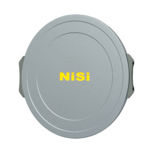 NisiMag67_13 NiSi JetMag Pro 67mm Magnetic Front Cap -etutulppa on pyöreä, hopeinen linssinsuojus, jonka keskellä on rohkea keltainen NiSi-tuotemerkki, sen sileässä pinnassa on hienovaraiset pyöreät urat ja sivuilla metalliklipsit.