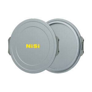 NisiMag67_15 Kaksi pyöreää, harmaata, metallista NiSi JetMag Pro Cap Kit -tulpat-suodatinkoteloa on esitetty päällekkäin, ja niiden etupuolella on keltainen "NiSi"-kirjain. Molemmissa koteloissa on sivuklipsit turvallista kiinnitystä varten.