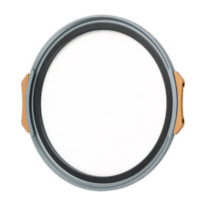 NisiMag67_6 Pyöreä, litteä NiSi JetMag Pro 67mm Black Mist 1/4 -suodatin, jossa on harmaa ja kultainen reunus ja valkoinen keskus, joka muistuttaa kameran linssinsuojusta, näkyy valkoista taustaa vasten.