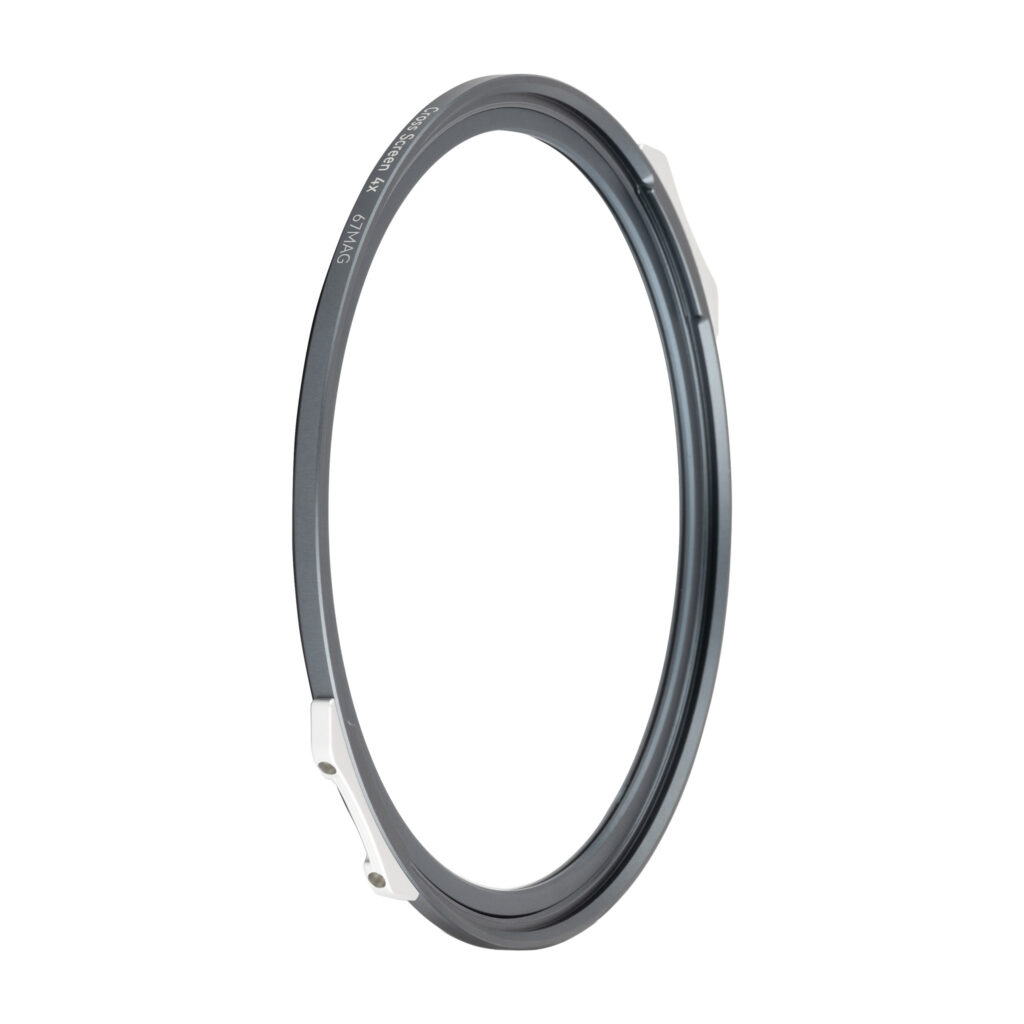 NisiMag67_8 Kuvassa NiSi JetMag Pro 67mm Cross Screen 4x -tähtiefekti-suodin: ohut, pyöreä metallirengas, jonka sivulla on kaksi pientä hopeista kiinnikettä, kuvattuna valkoista taustaa vasten.