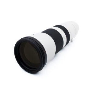 Sony FE 400-800mm f/6.3-8 G OSS (Kunto K5, Takuu 30kk) - Käytetty teleobjektiivi, jossa on mustat pitorenkaat ja jalustakiinnitys, kuvassa kuvakulmassa valkoisella pinnalla.