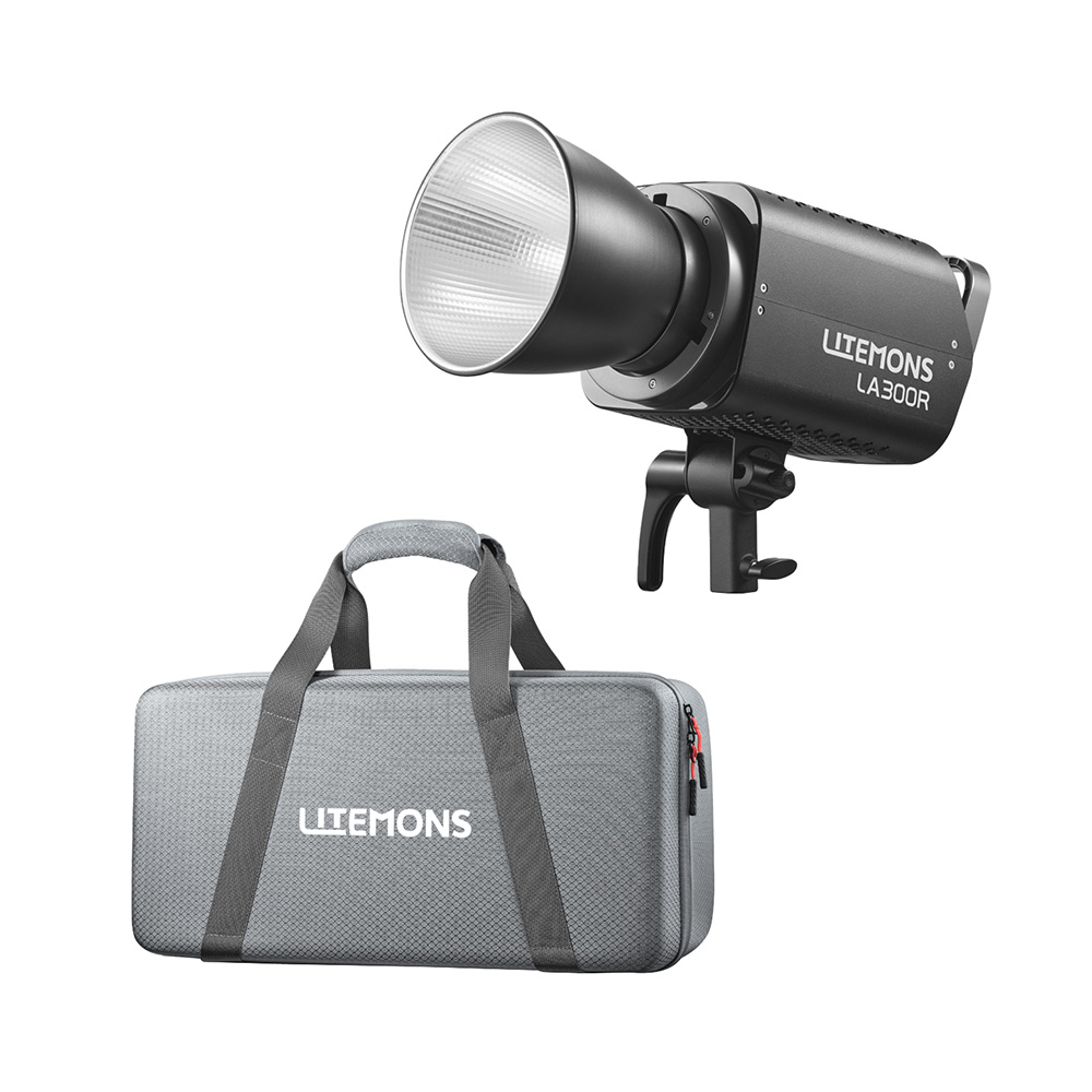 1750937968_003 Godox Litemons LA300R RGB LED Video Light Kit Musta, jossa on heijastin, asennettuna kiinnikkeeseen, näkyy harmaan kantolaukun yläpuolella, jossa on mustat kahvat ja punainen vetoketju, molemmissa on merkintä LITEMONS.
