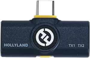 800q-01_128898 Lähikuvassa HOLLYLAND LARK M2 USB-C-VASTAANOTTAJASTA (SHINE CHARCOAL) näkyy USB-C-liitin, keskuslogo ja TX1/TX2-merkinnät sen tummansinisessä rungossa.