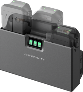 Grey Antigravity A1 Charging Hub charger with digital displays on 100 % and two batteries, each with a green indicator light.