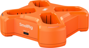 800q-01_135642 Vaalealla taustalla näkyy oranssi SmallRig 5748 nelikanavainen akkulaturi, jossa on neljä paikkaa ja sivussa USB-C IN -merkintä, joka on tarkoitettu akkujen lataamiseen.